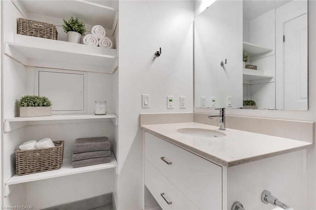Bathroom vanity featuring a light-colored countertop with an integrated sink and chrome faucet