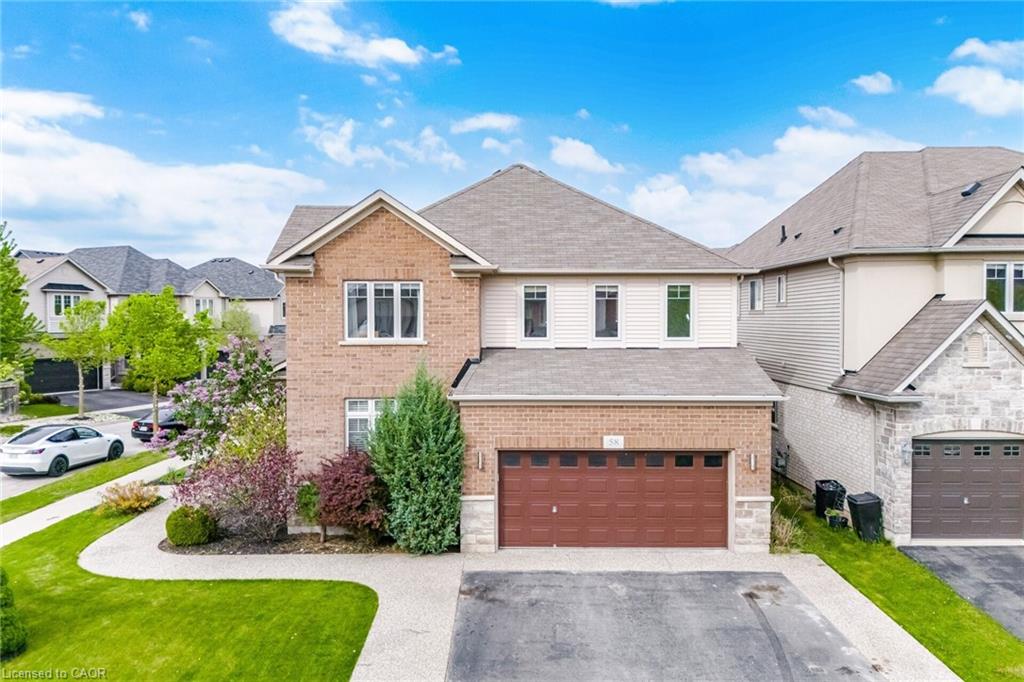 Two-story brick and siding residence featuring a two-car garage with a brown door