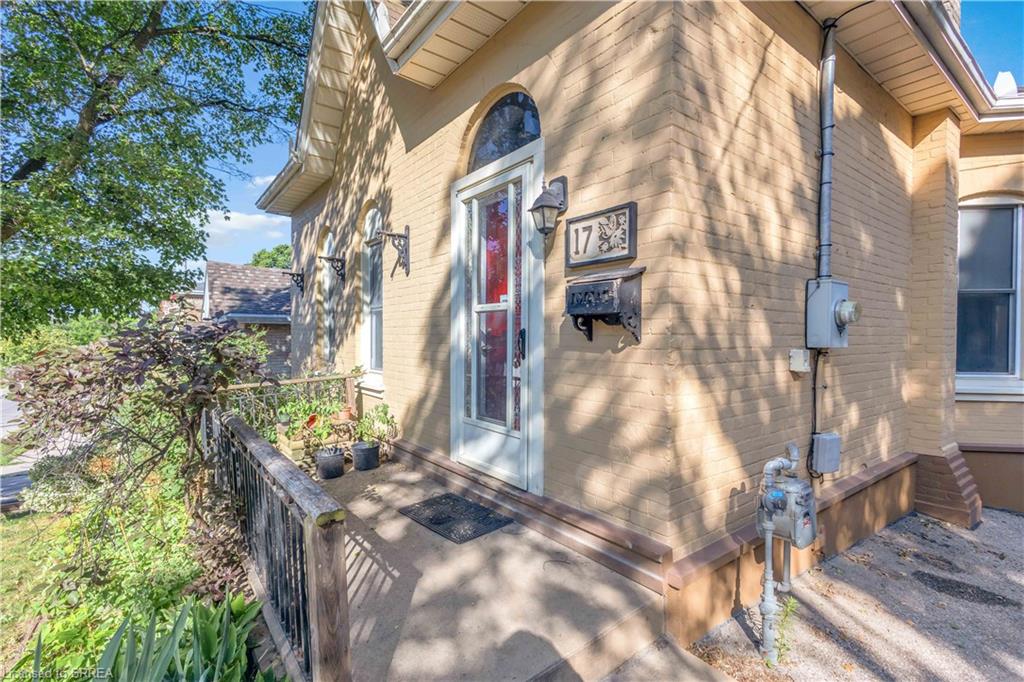 Brick exterior with arched entry door featuring stained glass accents