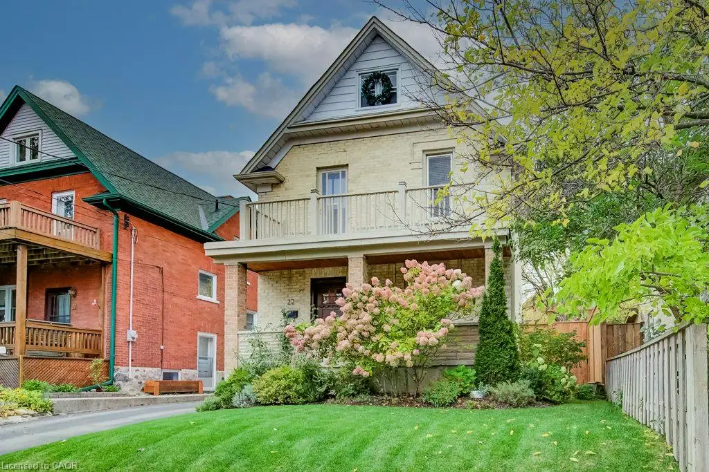 Two-story brick exterior featuring a covered front porch, an upper-level balcony with railing, and a gabled roofline