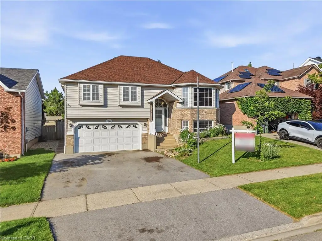 Two-story residence featuring light-colored siding and brick accents, an attached two-car garage, and a sloped driveway