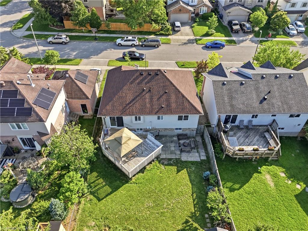 Expansive backyard featuring a manicured lawn, a large wood deck, and a stone patio