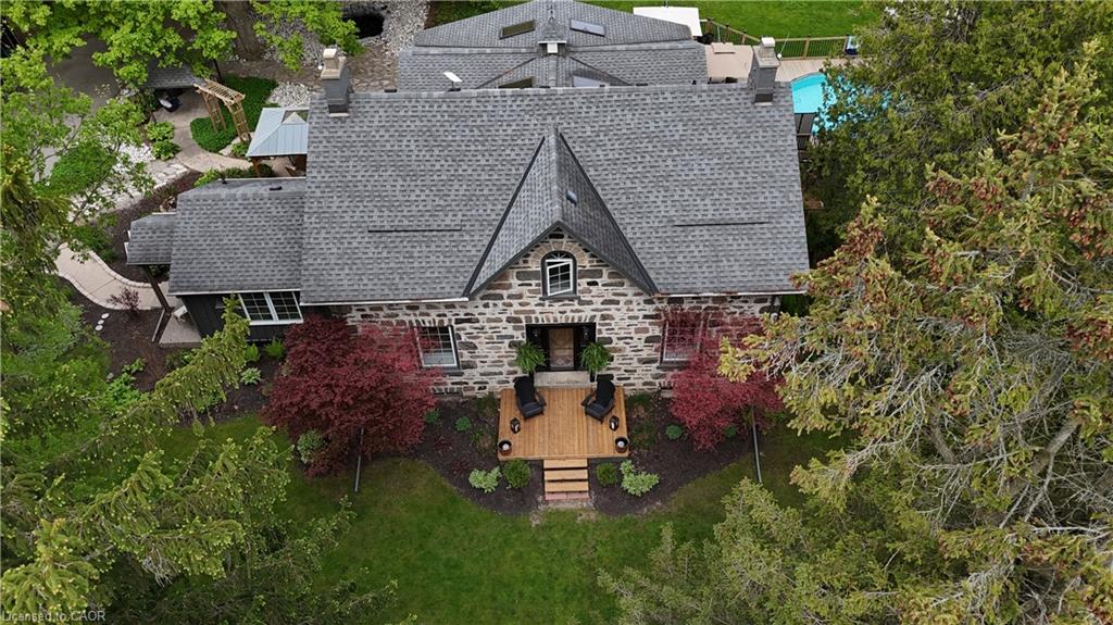 Stone facade residence featuring a multi-pitched shingle roof