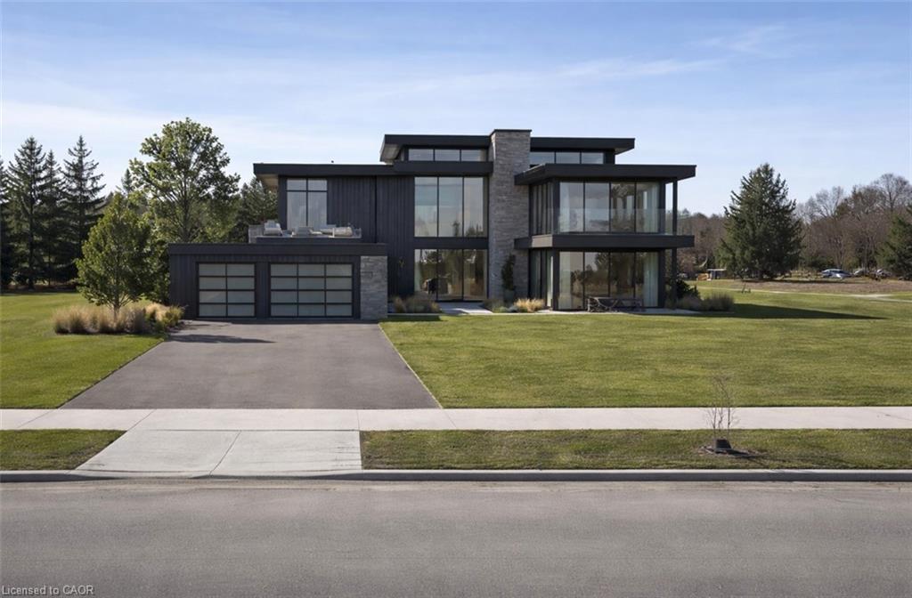 Contemporary house featuring a front yard, driveway, and a balcony