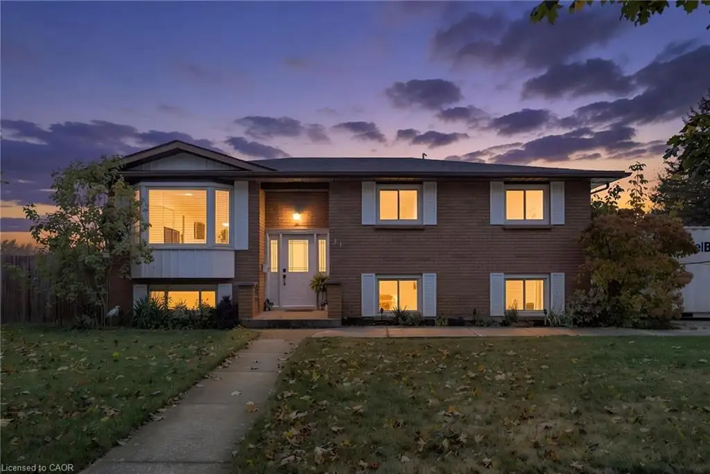 Brick exterior featuring a multi-level facade, prominent bay window, white window shutters, and a concrete walkway