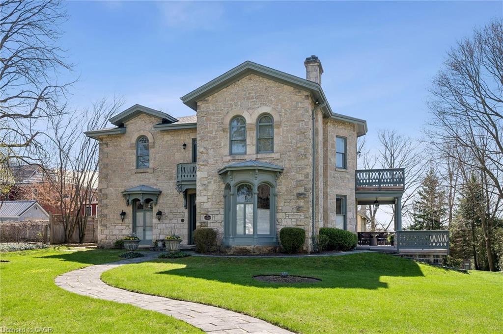 Stone exterior featuring arched windows, decorative trim, a bay window, and upper and lower decks