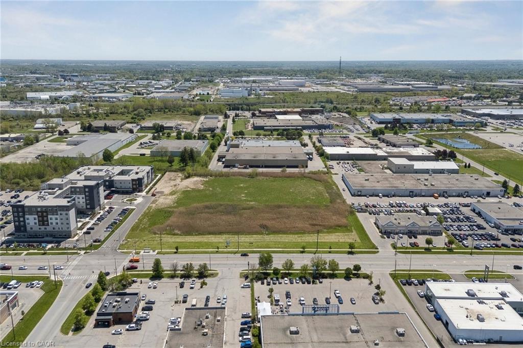 Expansive land parcel featuring existing road frontage and surrounding commercial and multi-unit developments