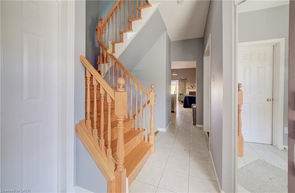 Wood staircase with balusters and handrails, complemented by light gray walls and white panel doors