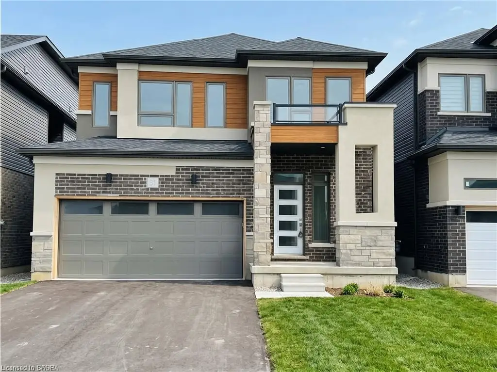 Contemporary two-story exterior featuring a stone and brick facade, a two-car garage, and a second-story balcony with glass railing