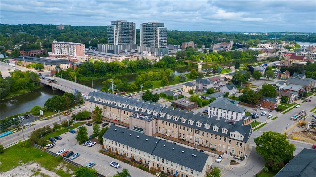 Aerial perspective showcasing urban residential buildings, proximity to a river, and surrounding green spaces
