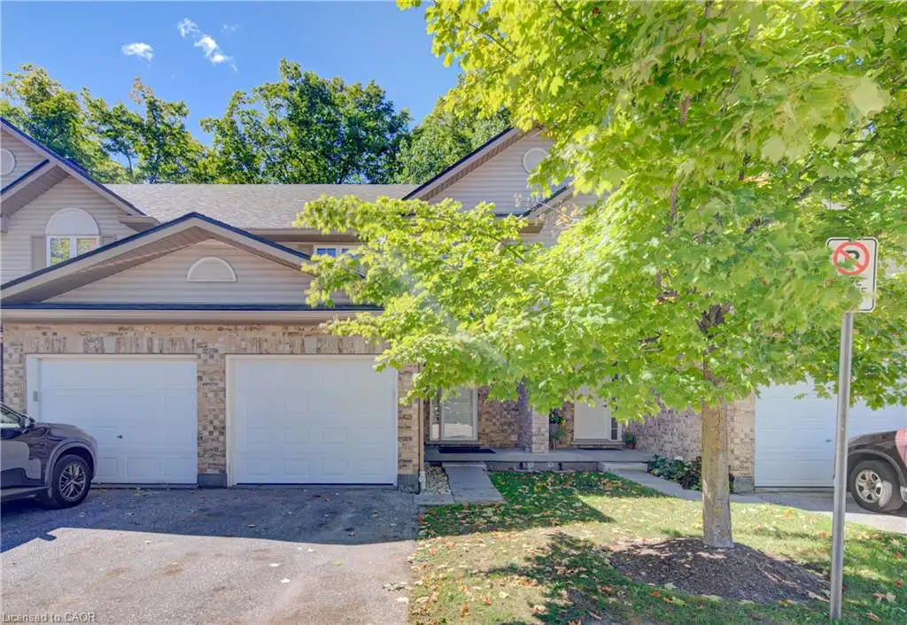 Brick and siding exterior with dual garage doors, a paved driveway, and a front walkway leading to the entrance