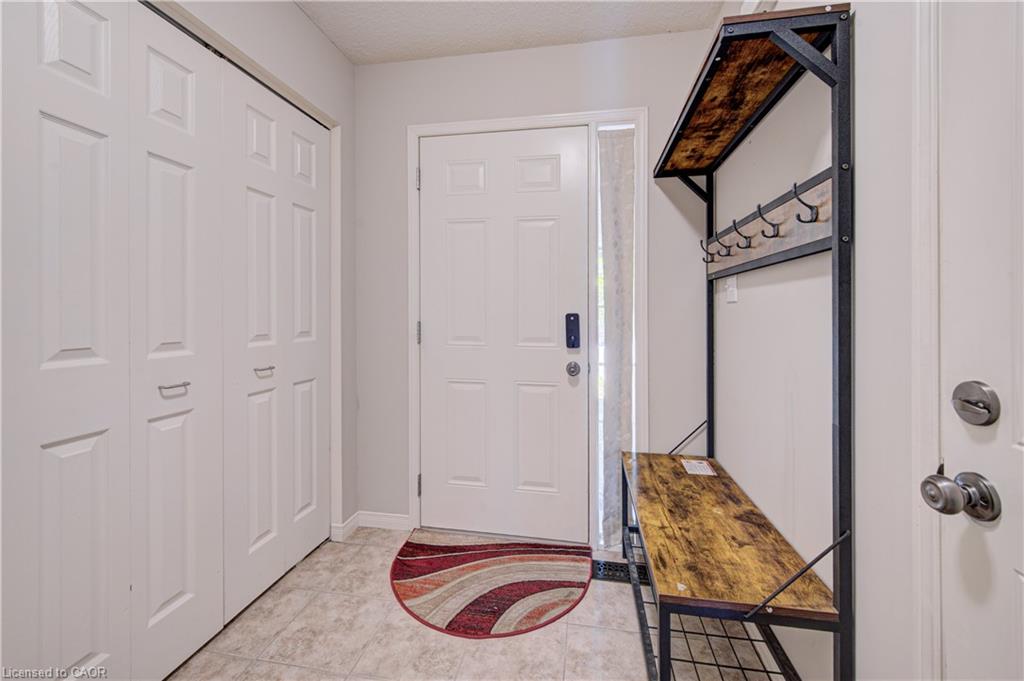 Entryway with a paneled white door, sidelight, and tiled flooring
