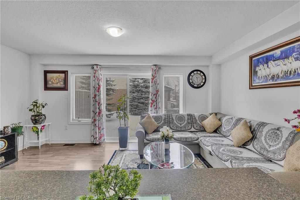 Light wood-finish flooring, white walls, recessed lighting, and a sliding glass door
