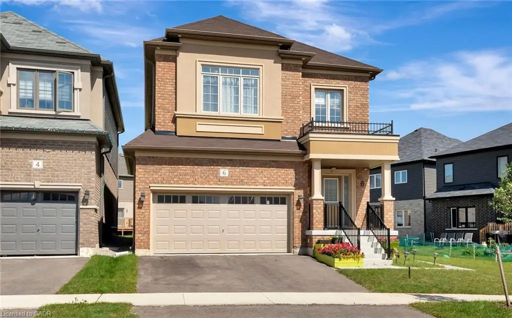 Two-story brick and stucco exterior featuring an attached two-car garage, a covered front entryway, and an upper-level metal-railing balcony