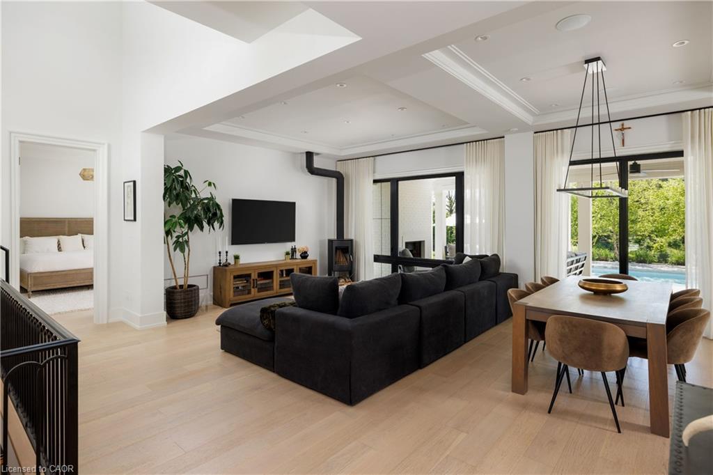 Light wood-finish flooring throughout, recessed lighting, and a modern freestanding fireplace