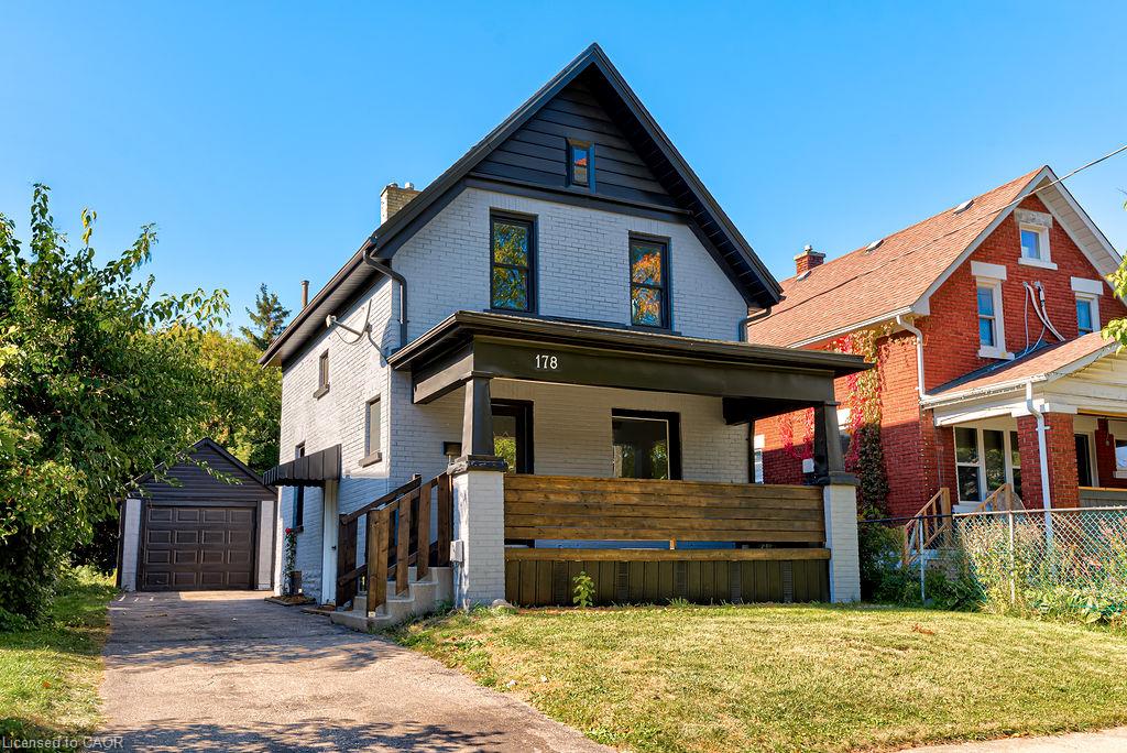Two-story residence with a covered front porch, a single-car detached garage, and a paved driveway
