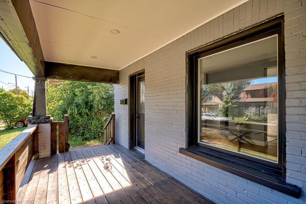 Covered porch with wood-finish decking, brick facade, and recessed lighting
