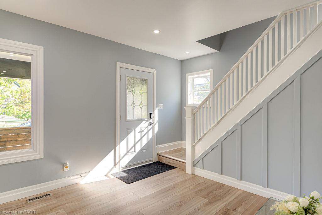 Entryway featuring wood-finish flooring, a white paneled door with decorative glass, and recessed lighting