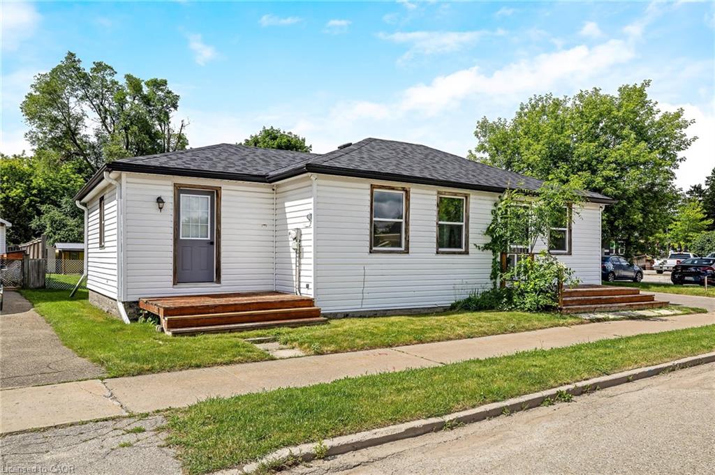 Charming single-story residence featuring clean white vinyl siding, a dark-pitched roof, and an inviting front entrance with a covered stoop