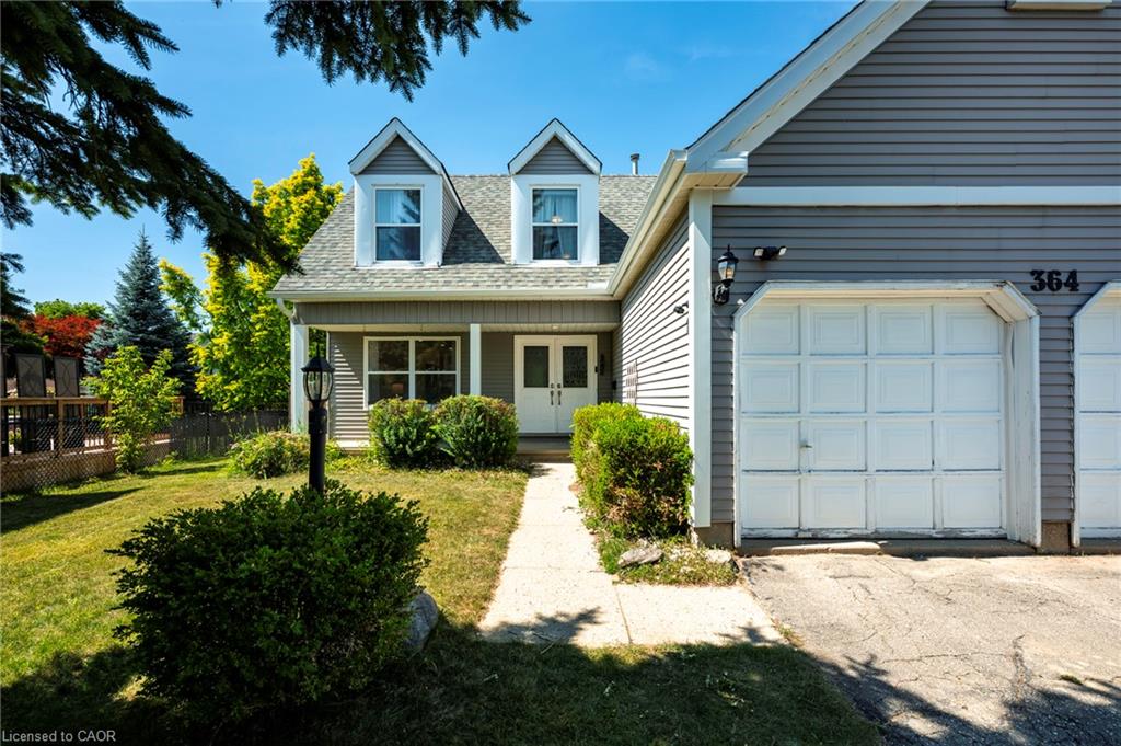 Classic Colonial-style residence featuring a mansard roof with dual dormers, vinyl siding exterior, and a two-car attached garage