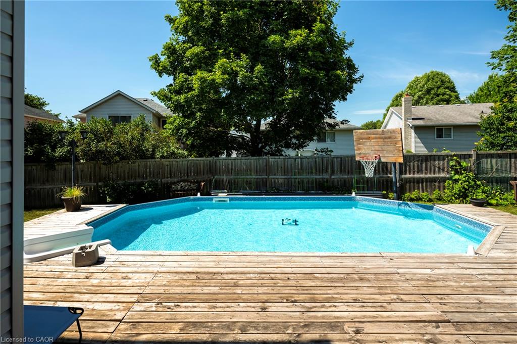 Backyard featuring a built-in swimming pool with a surrounding wood-finish deck