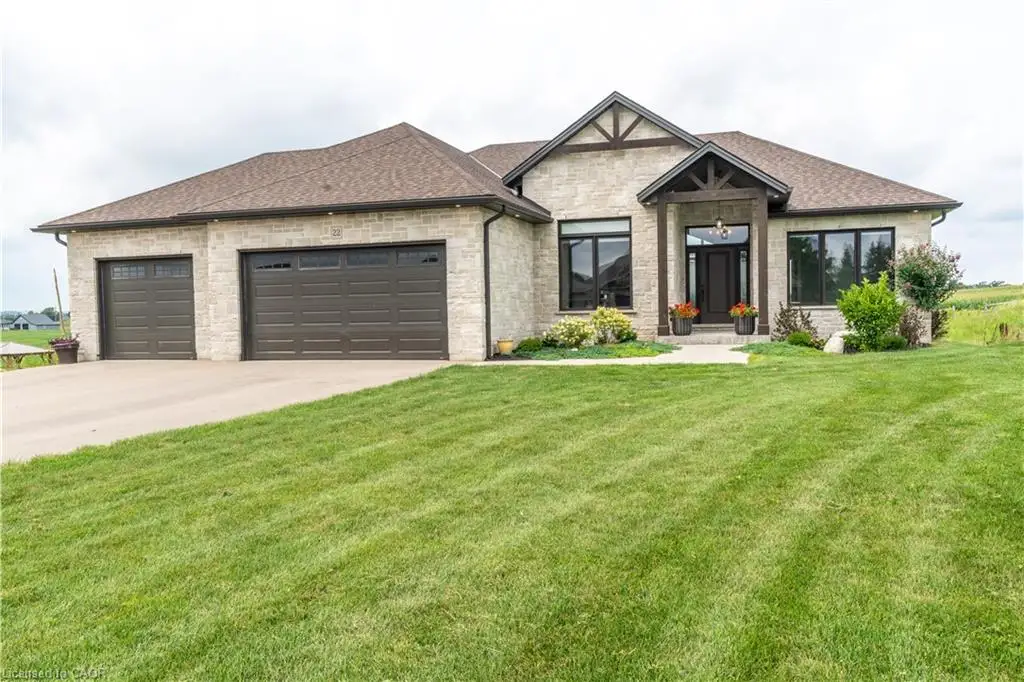 Stone veneer exterior with dark framed windows, prominent front entry with wood beam accents, and a two-car garage