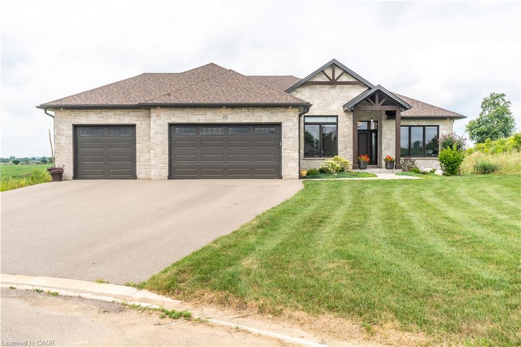 Stone facade with dark-framed windows, a prominent front entry with timber accents, and a two-car garage