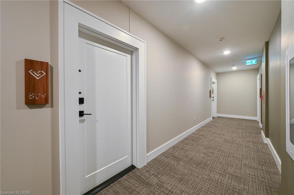 Hallway featuring a white entry door with matte black hardware