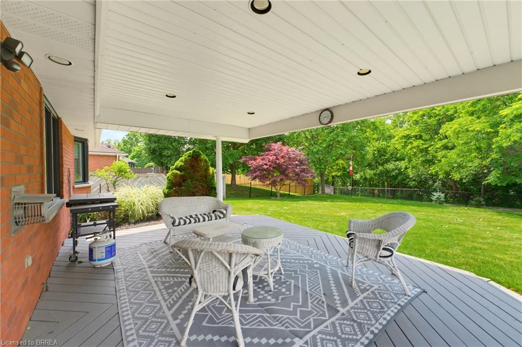 Expansive covered deck featuring recessed lighting, a ceiling fan, and a large open lawn beyond