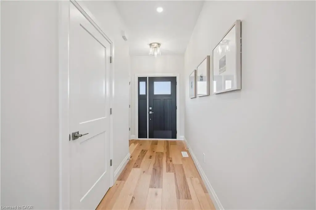 Entryway featuring wood-finish flooring, a solid-core door with a glass inlay, neutral wall paint, and recessed ceiling lighting