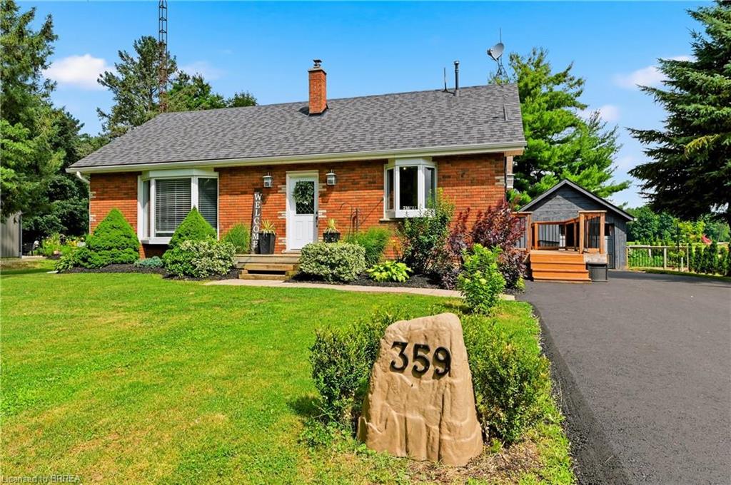 Brick exterior with a gray shingle roof, bay window, and a white front door