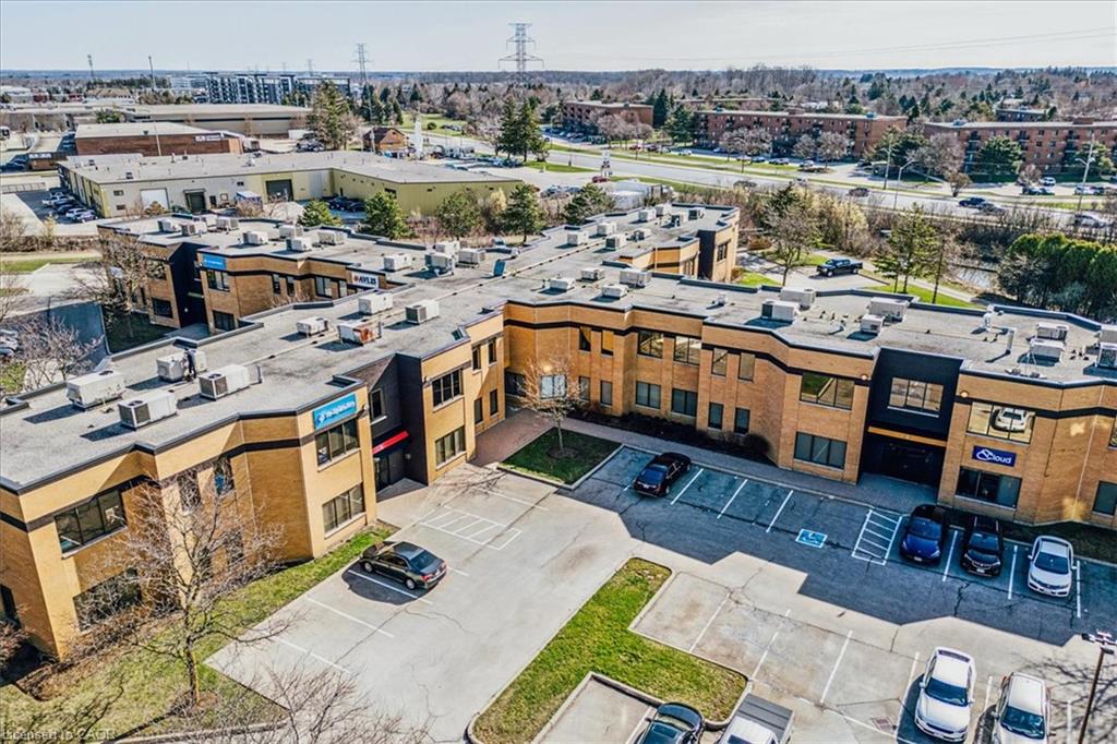 Multi-story commercial building with an expansive parking lot, multiple entry points, and a prominent commercial signage panel