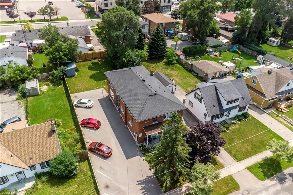Multi-unit residential property featuring a brick exterior and a dark shingle roof
