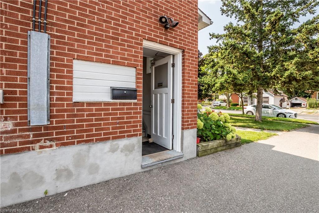 Brick exterior with a white entry door, recessed wall panel, and planter box