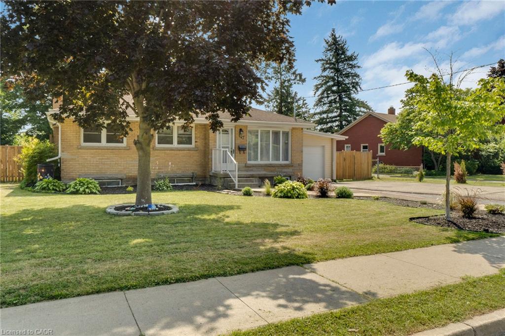 Brick exterior featuring a well-maintained lawn and established landscaping