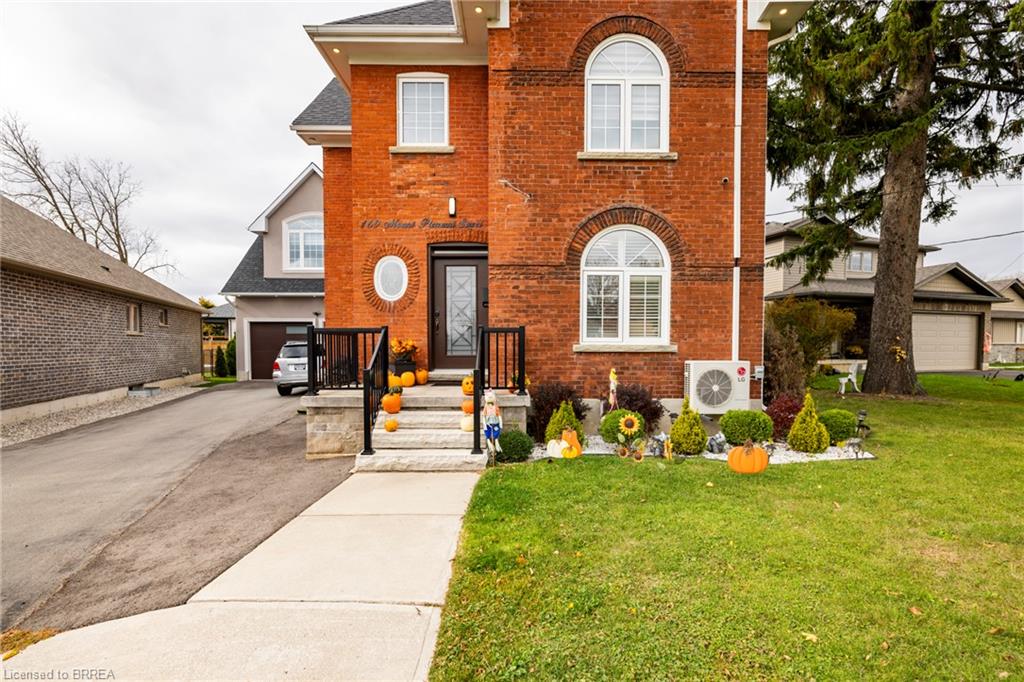Entrance to property with a yard, ac unit, and a garage