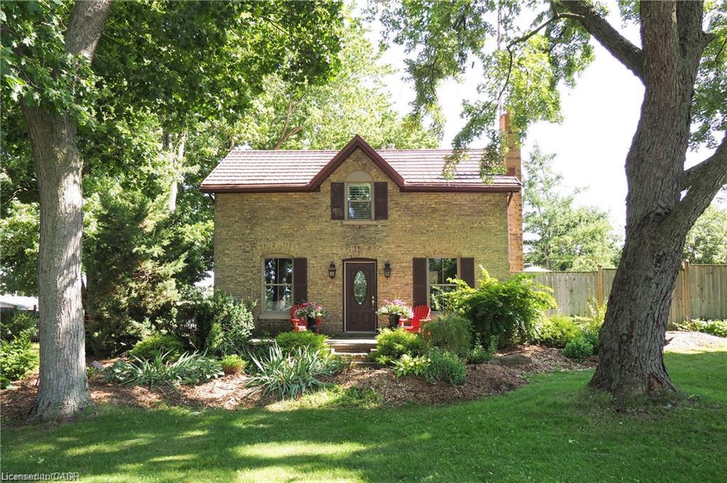 Brick exterior with a gabled roofline, front dormer, and dark window shutters