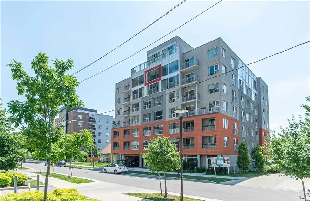 Modern multi-story building featuring a mixed-material facade with grey panels and red brick accents