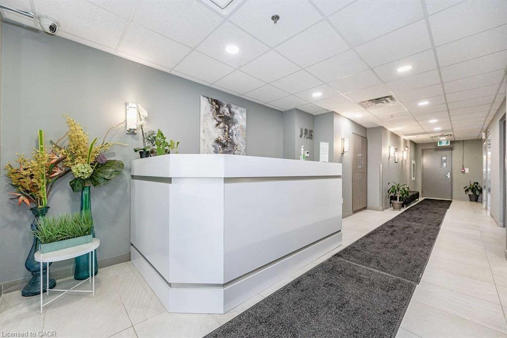 Modern reception area featuring a white desk, recessed lighting, and sconce fixtures