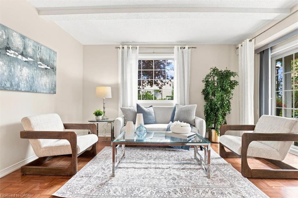 Living room featuring wood-finish flooring, a large window with grilles, and a glass sliding door