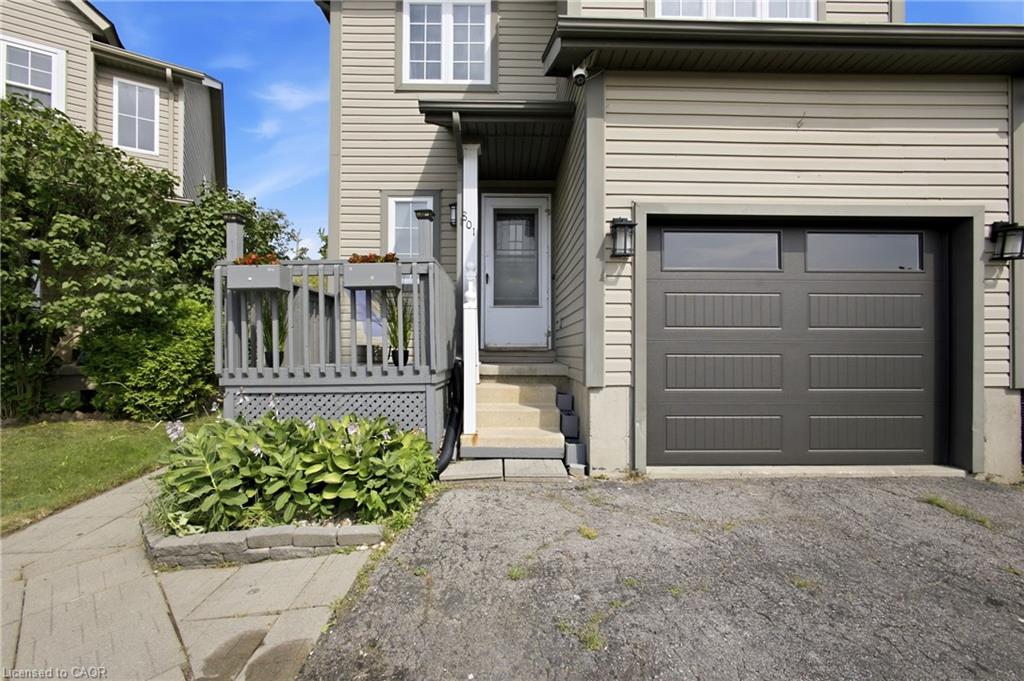 Two-story exterior with horizontal siding, covered entry, attached garage with windows, and a raised wooden deck