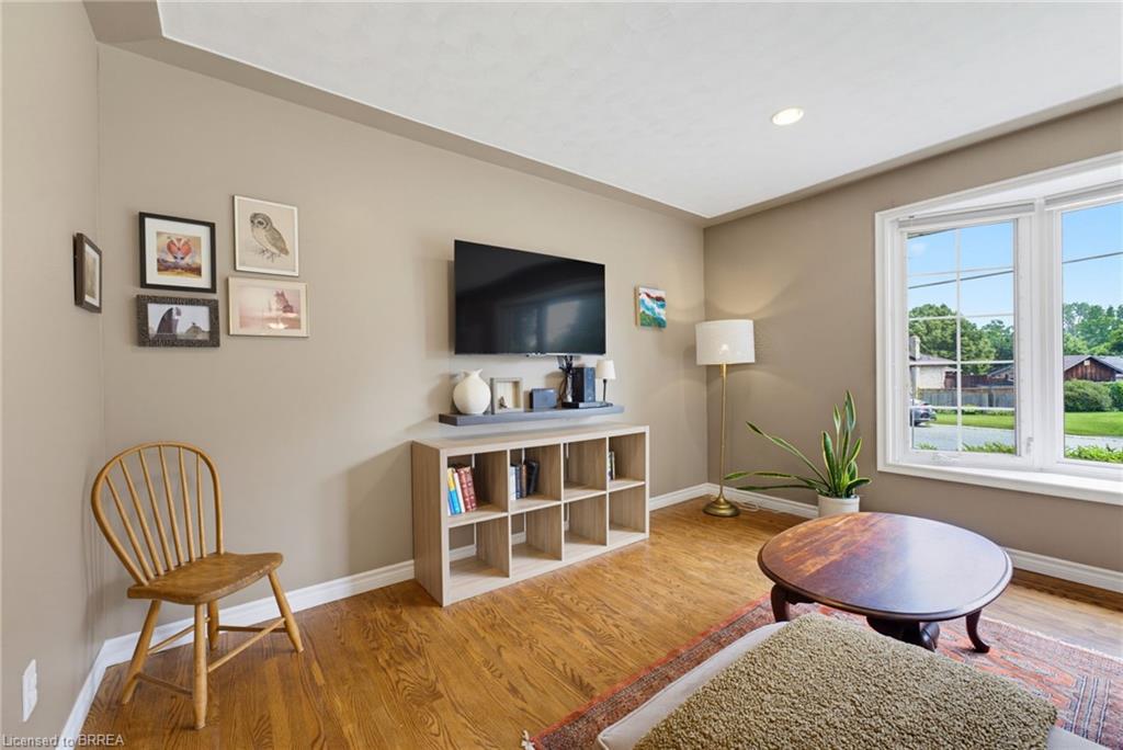 Hardwood flooring, neutral wall paint, recessed lighting, and a multi-pane window