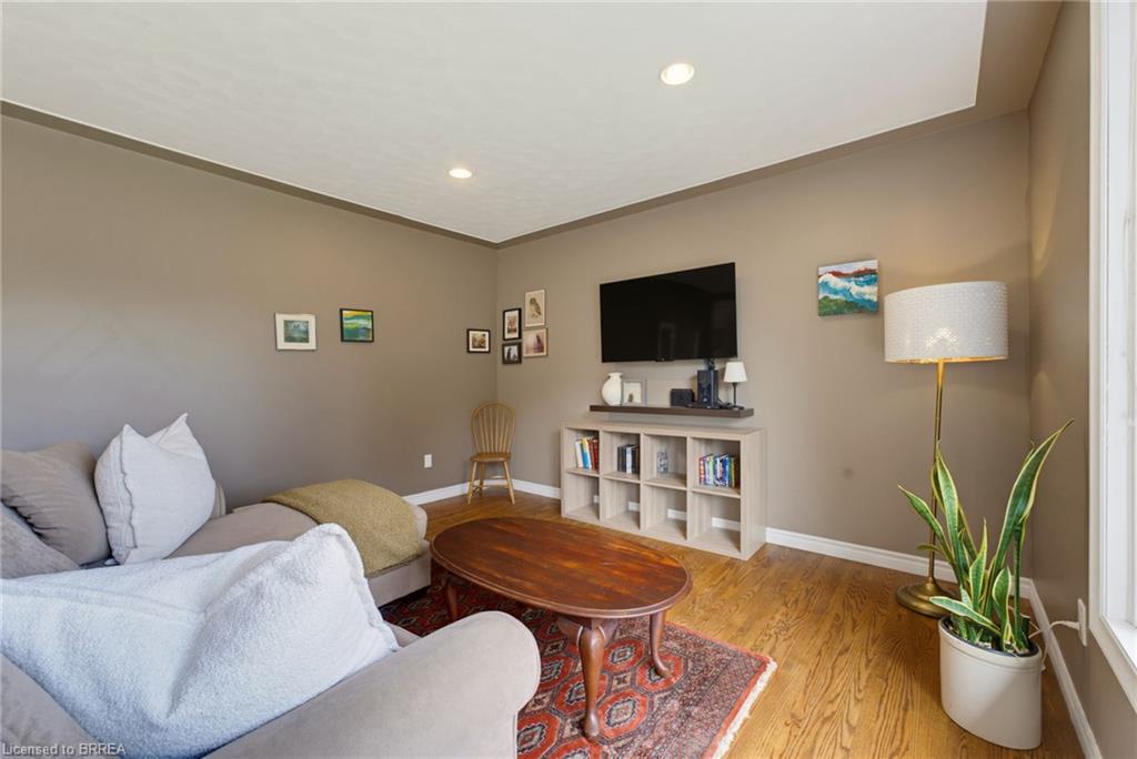 Wood-finish flooring, recessed lighting, crown molding, and neutral wall tones