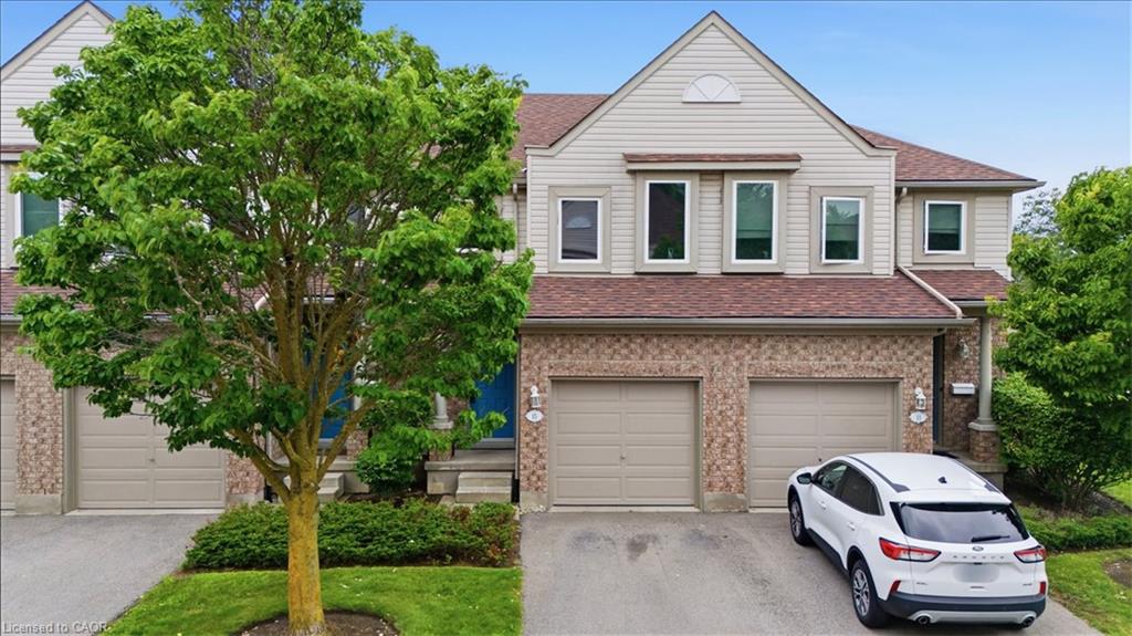 Brick and siding exterior featuring a multi-car driveway, attached garage, and multiple windows