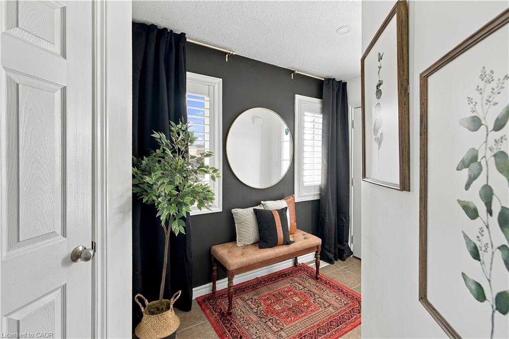 Recessed ceiling lighting, white interior door with paneling, window with white louvered shutters, dark accent wall, and tiled flooring