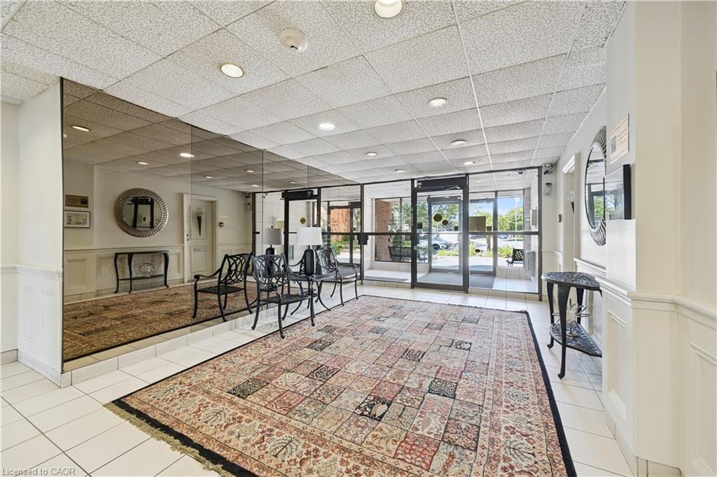 Spacious lobby area featuring white tile flooring, wainscoting, and large mirrored wall panels