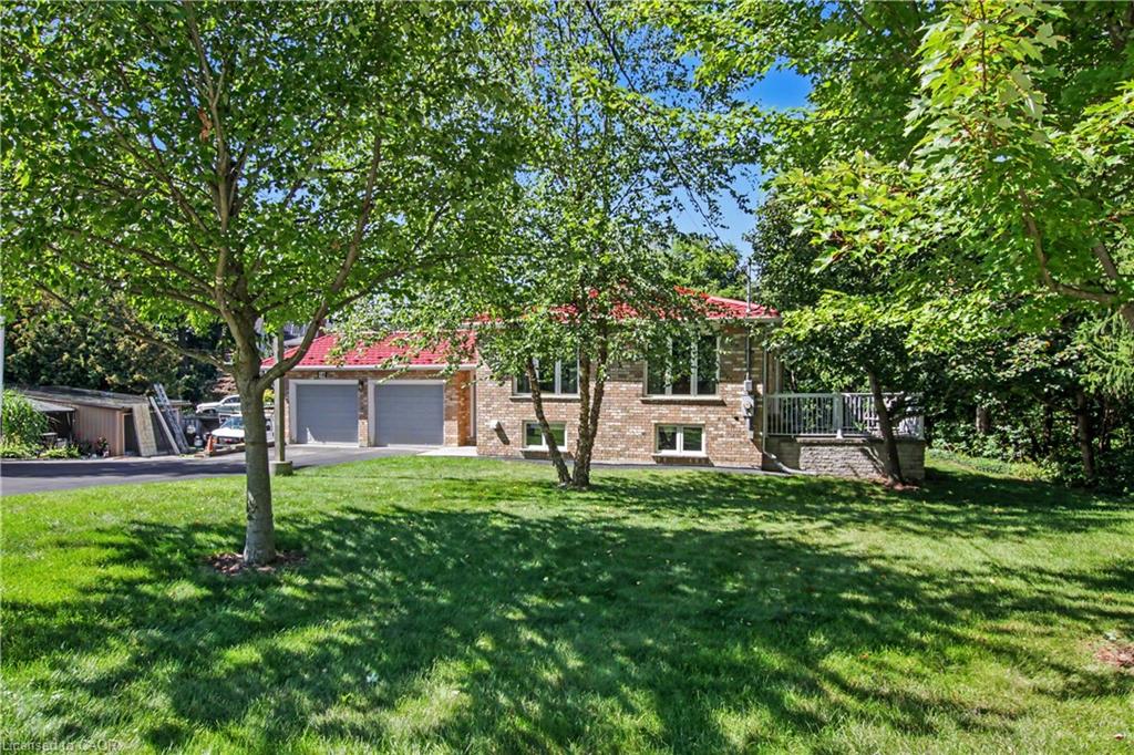 Brick exterior with a red roof, featuring a two-car garage and a raised deck with white railings