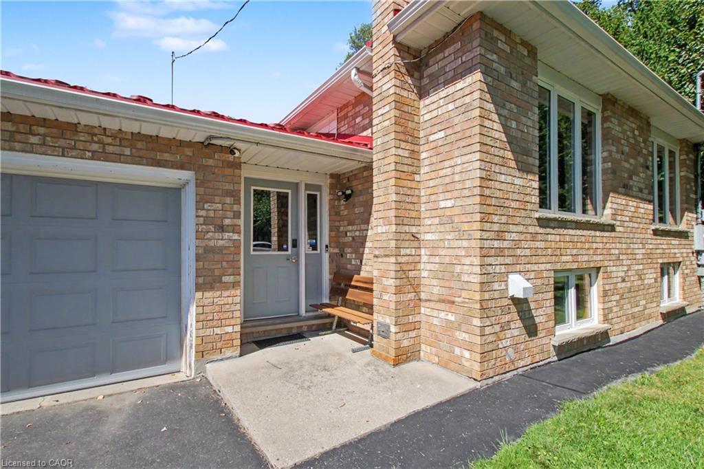 Brick exterior with a red roof, attached garage, and a covered entry