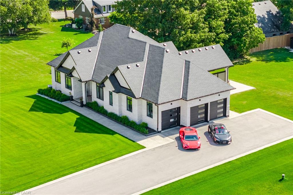 Contemporary residence featuring a light-colored brick exterior, dark-framed windows, and a multi-gabled roofline