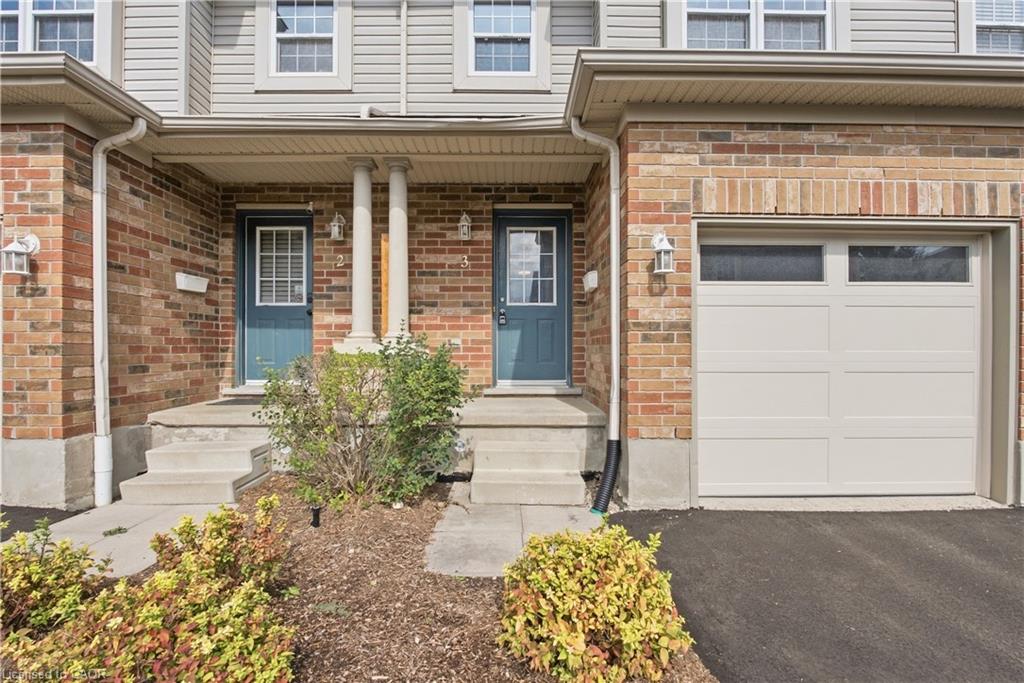 Brick and siding exterior with concrete steps, covered entry, and integrated garage featuring transom windows